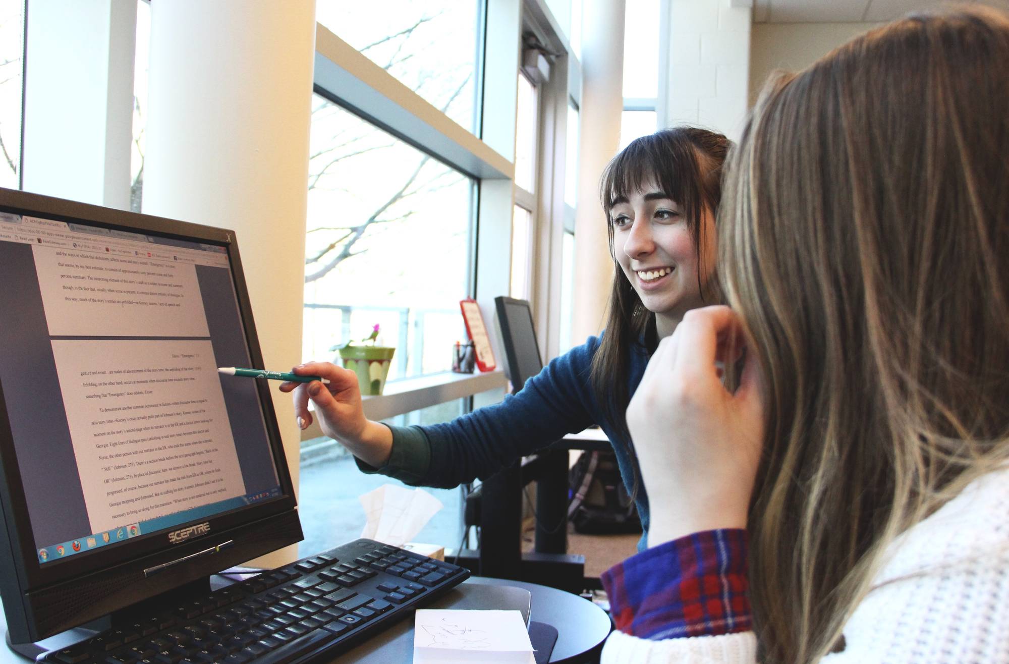 A Writing Consultant and a student working together at a computer